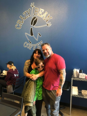 parents and child posing in the busy cafe